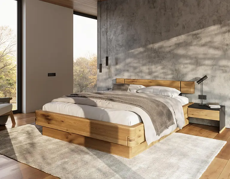 Schlafzimmer mit Bettgestell aus massiver Eiche vor betonierter Akzentwand, raumhohen Fenstern mit Waldblick und minimalistischer Dekoration